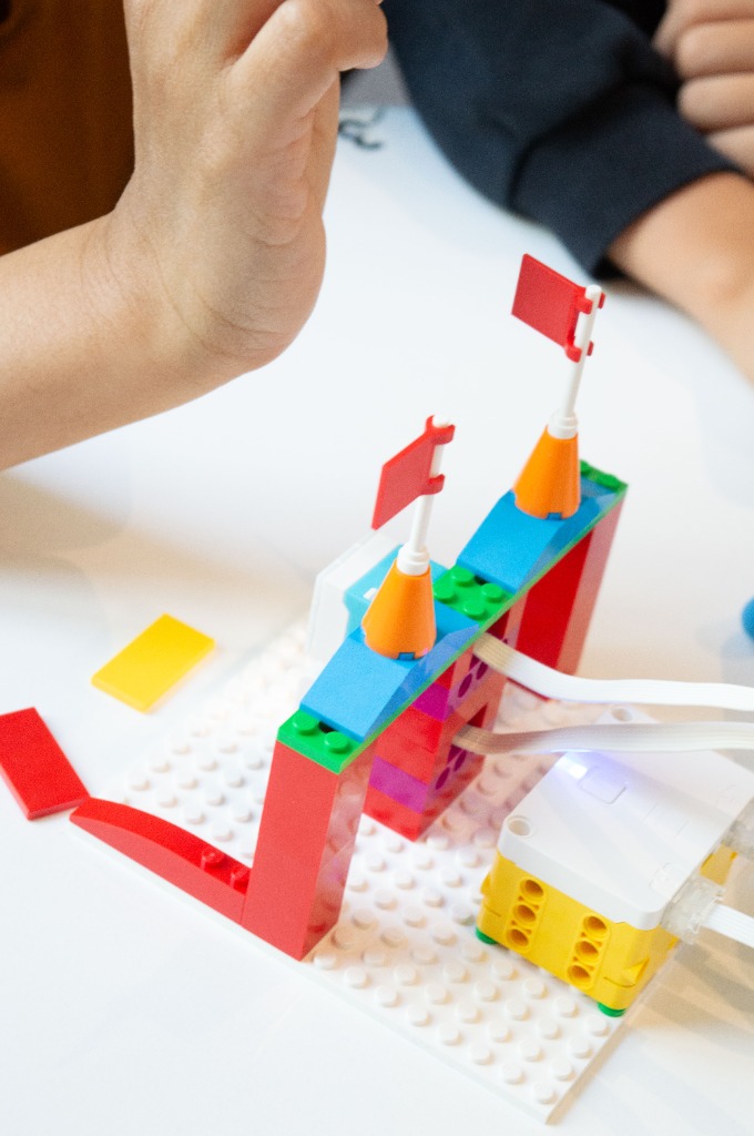 Un enfant construisant un modèle robotique motorisé avec des drapeaux